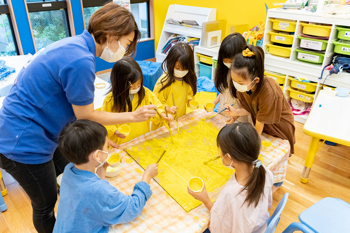 段ボールに絵の具をたっぷり。幼児クラスの子どもたち。