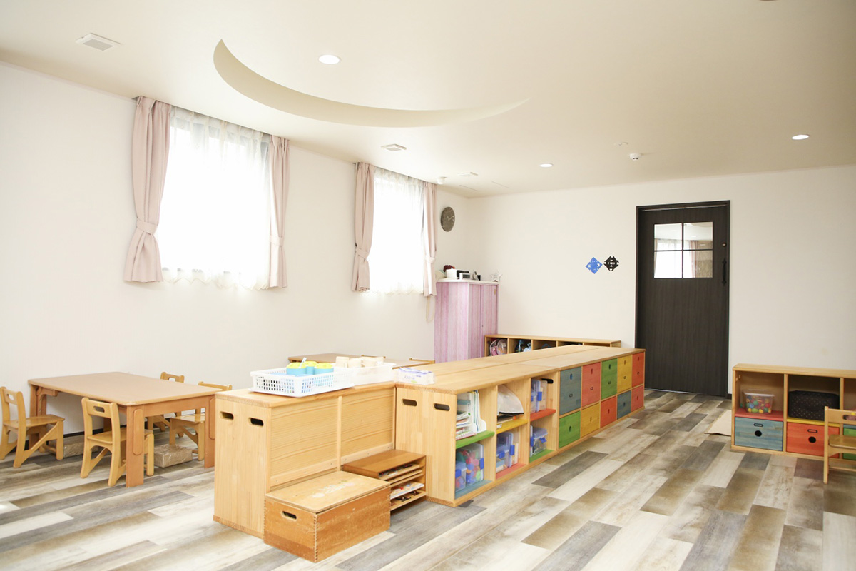 照明や窓、収納、家具など明るく優しい色合いが特徴の保育室。